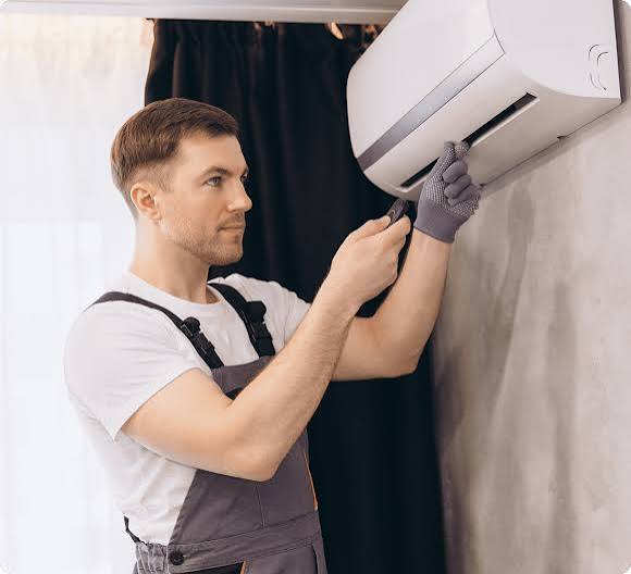 Technician repairing wall-mounted mini split unit in finished bonus room