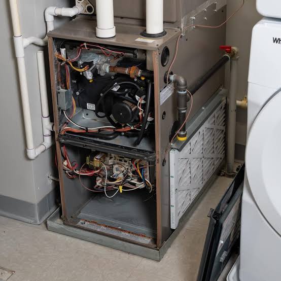Technician diagnosing furnace failure in Hall County home during cold morning